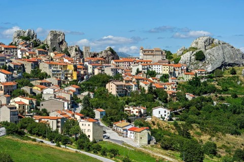 View of mountain village Pietrabbondante with medieval tower and church Chiesa di Santa Maria Assunta on rock Morg Caraceni