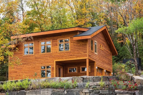 Luxurious stained cedar and timber wood 2-car garage with upstairs floor and landscaping in autumn