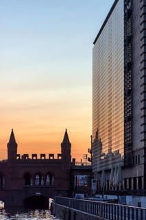 Modern skyscraper and Oberbaum bridge in the evening light