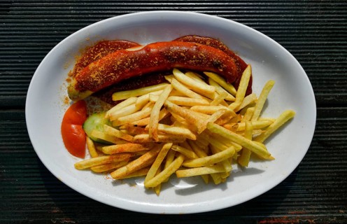 Curry sausage with French fries on plates