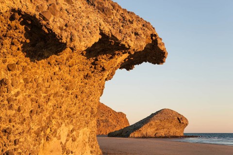 Fossilized lava tongues and walls at the beach Playa del Monsul