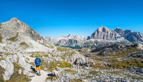 Hiker with climbing helmet on footpath to the Nuvolau