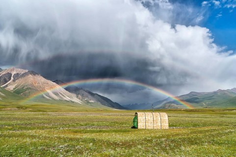 Tent under a rainbow over meadow
