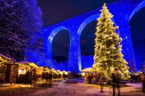 Snowy Christmas market under a railway viaduct