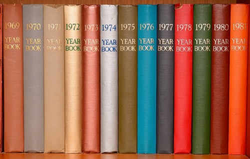 Year-books in different colors in a shelf