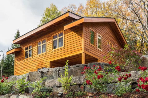 Luxurious stained cedar and timber wood 2-car garage with upstairs floor and landscaping in autumn