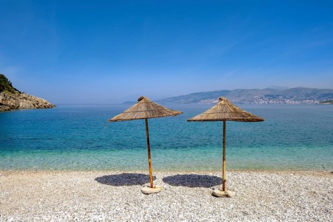 Reed-covered parasols on the gravel beach