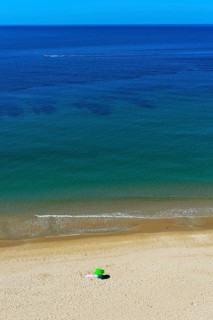 Solitary parasol on an empty sandy beach near Praia da Luz