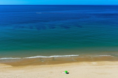 Solitary parasol on an empty sandy beach near Praia da Luz