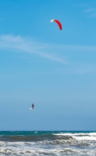 Kitesurfer in the air over sea with waves
