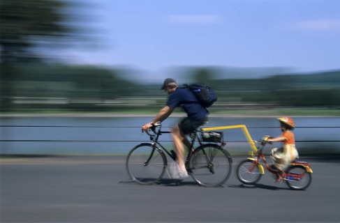 Cyclist and girl wearing bicycle helmet cycling