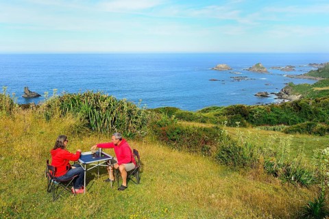 Couple plays board game on camping table
