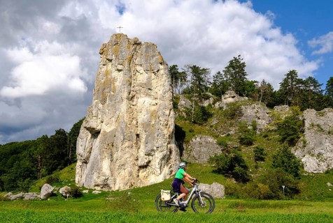 Cyclist in front of climbing rock Burgstein