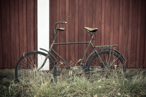 Old bicycle leans against a Swedish red wooden house