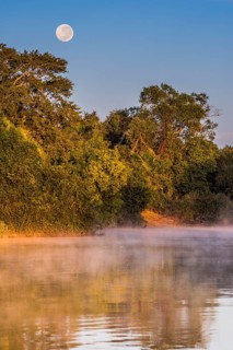 Full moon and morning fog at sunrise over the Rio Negro in the southern Pantanal