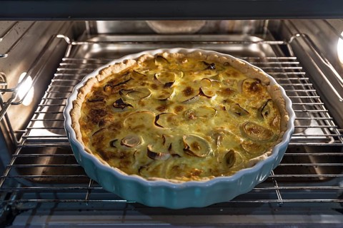 Baked leek quiche in round form in the oven