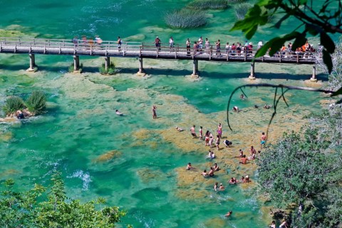 Tourists bathe at the waterfall Smotorcycleinski Buk