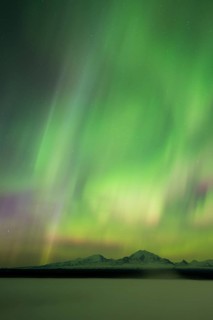 Aurora over the fog shrouded Copper River and mounts Sanford Drum and Wrangell