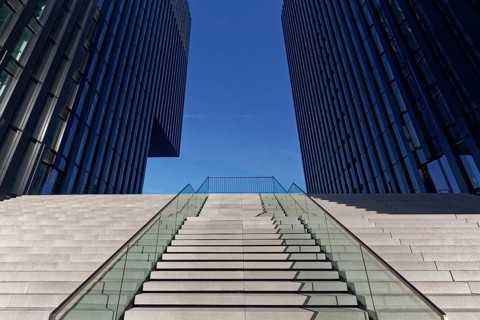 Wide staircase leading upwards between skyscrapers
