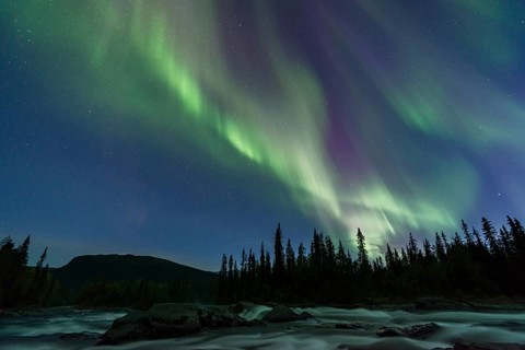 Northern Lights or Aurora Borealis above river Gamajahka or Kamajakka