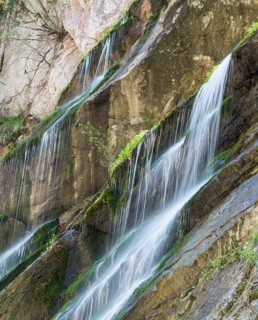Waterfall on mossy slope in gorge