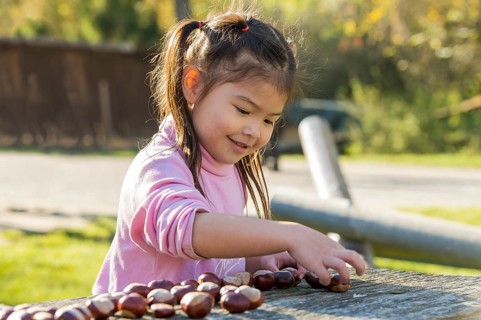 Eurasian girl sitting at wooden table
