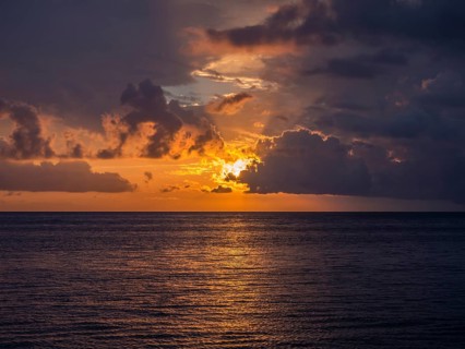 Sunset behind clouds over the sea