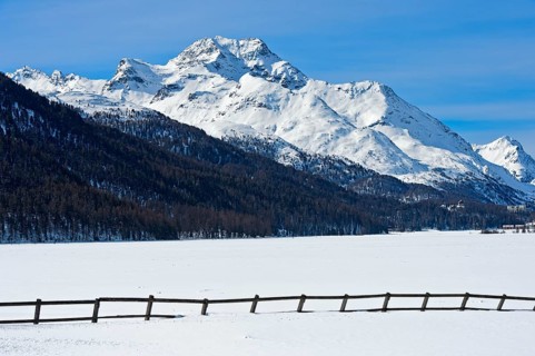 Summit Piz de la Margna above the frozen Lake Silvaplana