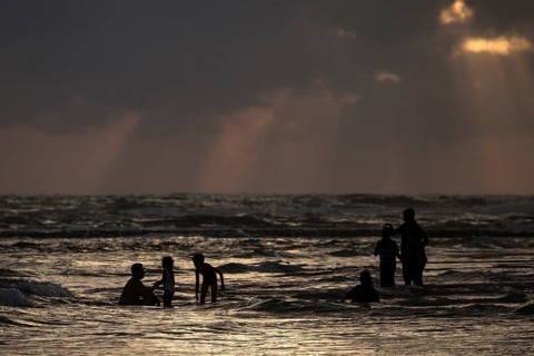 People in backlight in water