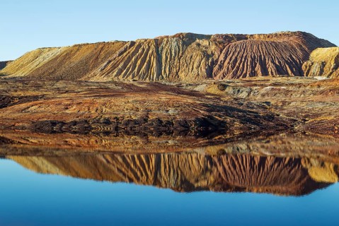 Mineral-rich ground and rocks with rainwater pool at Rio Tinto mines