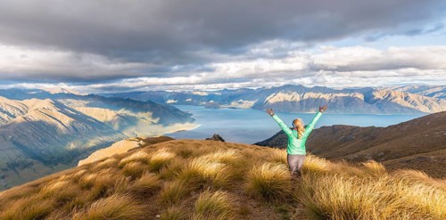 Female hiker stretching arms in the air