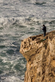 Cliff fisher at steep coast