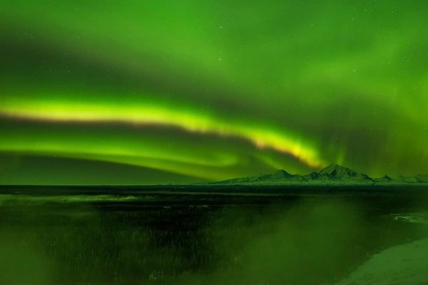 Aurora over the fog shrouded Copper River and mounts Sanford Drum and Wrangell