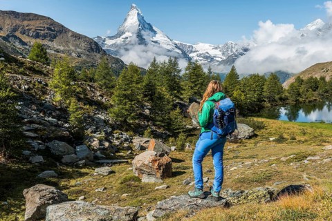 Hiker stands on rocks and looks into the distance