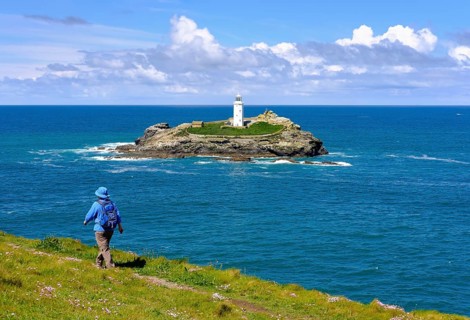Woman hikes on coastal route at Godrevy Point