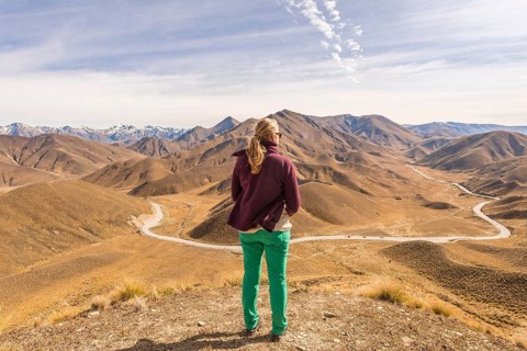 Woman looking over stark mountains