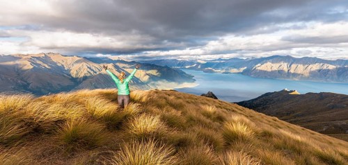 Female hiker stretching arms in the air