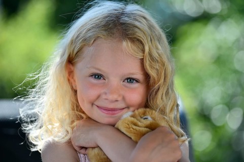 Little girl with blonde hair and cuddly toy
