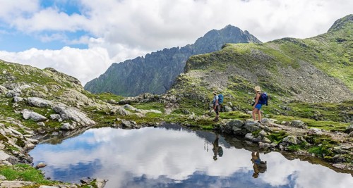 Two hikers by a mountain lake