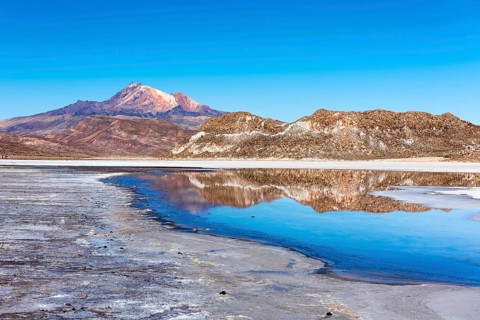 Volcano Cerro Tunupa with reflection in the Salar de Uyuni