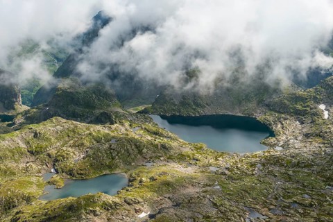 Clouds passing over a ridge with mountain lakes