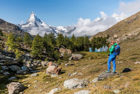 Hiker stands on rocks and looks into the distance