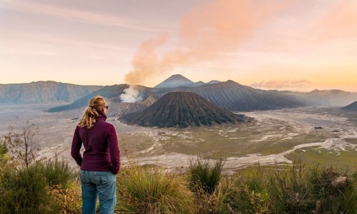 Tourist in front of landscape at sunset