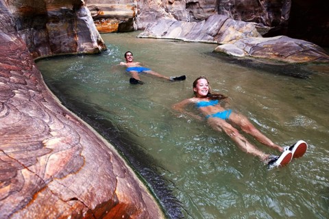 Young couple floats at the canyon of Wadi Mujib