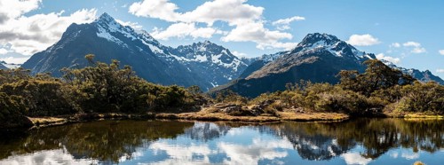 Small mountain lake with reflection of the mountain chain