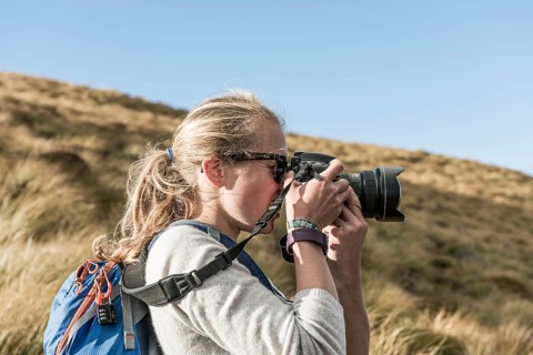 Female hiker taking picture with a reflex camera