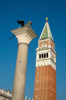 Winged lion on granite column with church tower of Basilica di San Marco