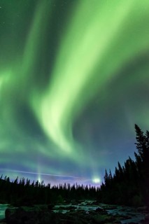 Northern Lights or Aurora Borealis above river Gamajahka or Kamajakka