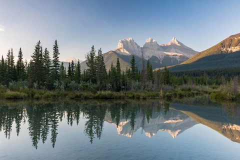 Three Sisters reflecting in calm water