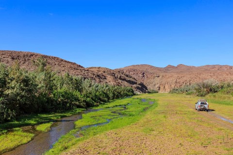 Off-road vehicle drives in the Hoarusib river bed